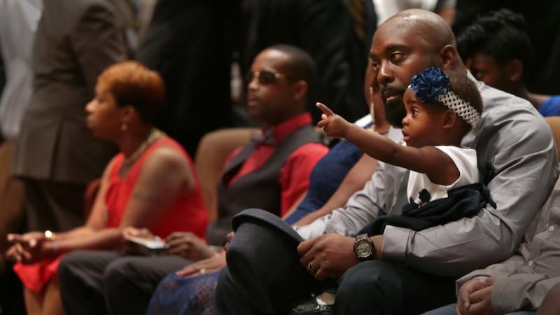 Michael Brown Sr sits with an unidentified girl on his lap during the funeral services for his son Michael Brown.Photograph: Getty