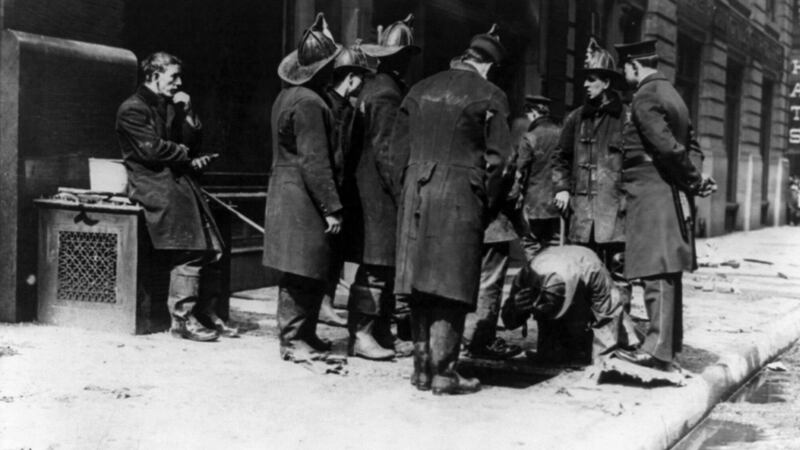 Firemen gather on the sidewalk at 23-29 Washington Place (the Asch Building) while searching for bodies at the site of the Triangle Shirtwaist Factory fire, New York, 1911. Photograph: Buyenlarge/ Getty
