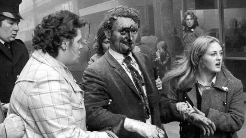 Bloodied and shaken Tom McFarlane is lead away from the scene of the bombing