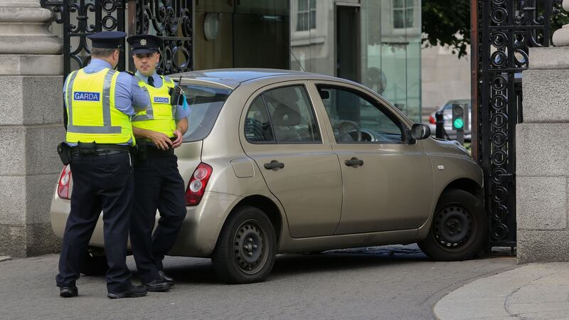 Gardaí at the scene of a collision where a car crashed into the gates of Government Buildings in Dublin. Photograph: Collins