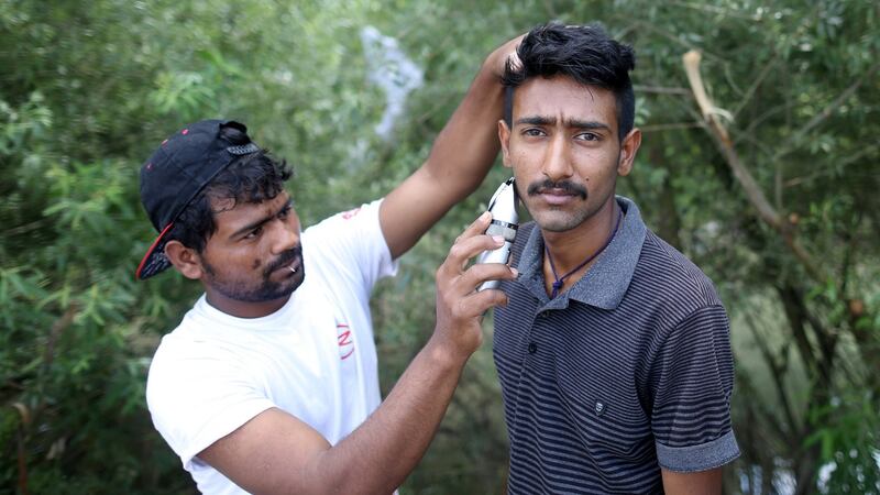 A migrant shaves his friend in Velika Kladusa at the Bosnia-Croatia border. Photograph: Dado Ruvic