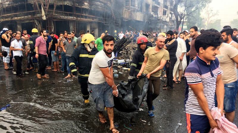 Firefighters and civilians carry the bodies of victims killed in the car bomb attack in Karrada, Baghdad. Photograph: Khalid Mohammed/AP Photo