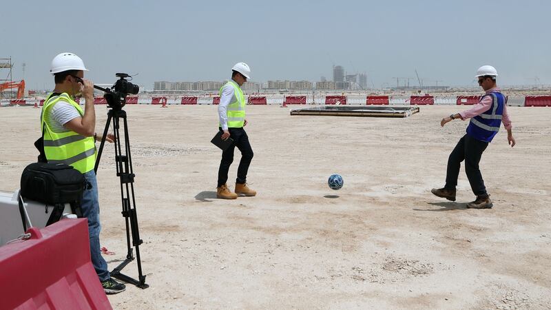 Tamim Loutfi Elabed (R), project manager of the construction of Lusail stadium, the 80,000-seater venue which will host the opening match and the final plays football on the site of the stadium. Photo: Karim Jaafar/Getty Images