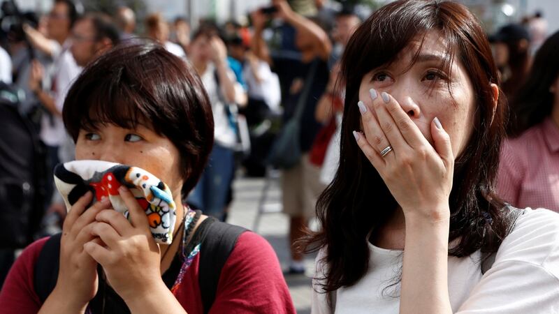 People in Tokyo watch a large screen showing Japanese emperor Akihito’s video address on Monday. Photograph: Kim Kyung-Hoon/Reuters