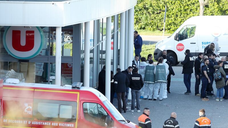 French police, forensic experts and members of a victims assistance unit stand at the entrance of the Super U supermarket where a gunman held hostages in Trebes, southern France. Photograph: Sebastian Nogier/EPA