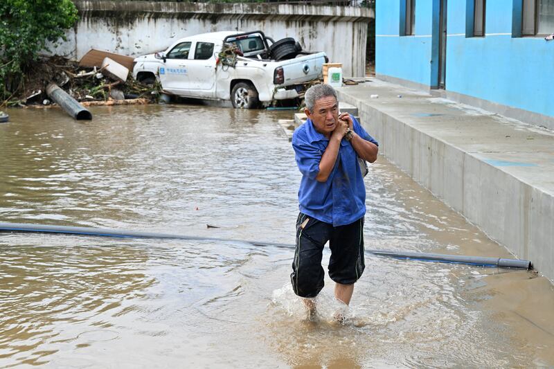 A man salvages items in Miyun district, northern Beijing. Photograph:  Adek Berry/AFP via Getty Images        