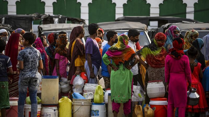 People in New Delhi fill cans from a water distribution tanker as the government eases a nationwide lockdown. Photograph: Sajjad Hussain/AFP