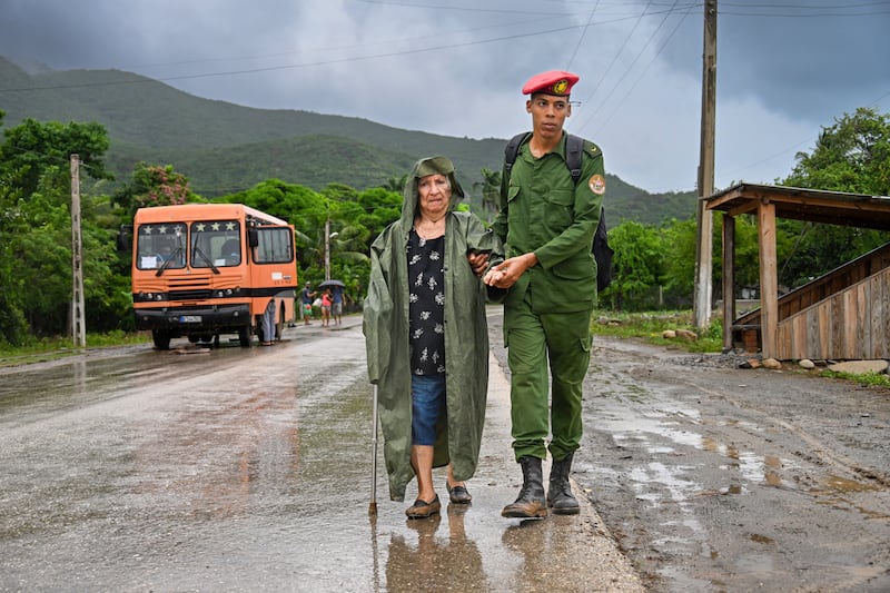 A soldier helps to evacuate an elderly woman at Siboney beach  in Santiago de Cuba. Photograph: Yamil Lage/AFP via Getty Images         