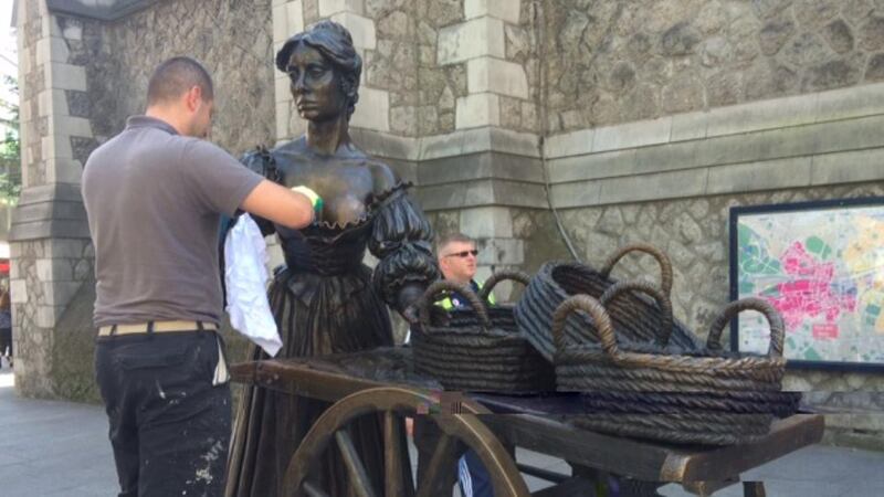 The Molly Malone statue being cleaned by a member of Dublin City Council. Photograph: Eric Luke