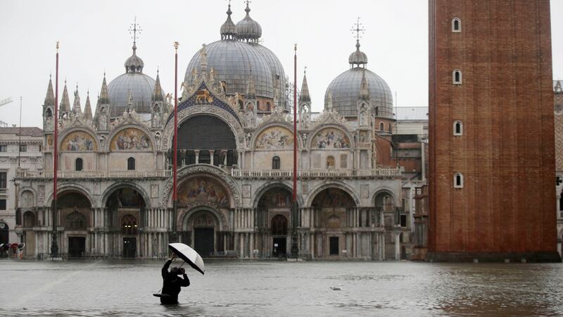 A photographer takes pictures in a flooded St Mark’s Square in Venice, Italy on  Tuesday. Photograph: Luca Bruno/AP