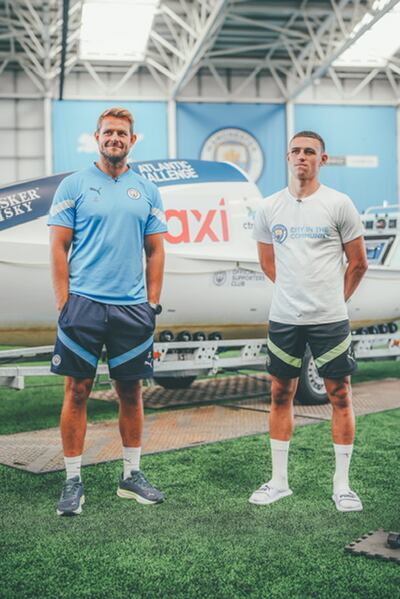 Jamie Carr and Phil Foden with the boat he will row across the Atlantic