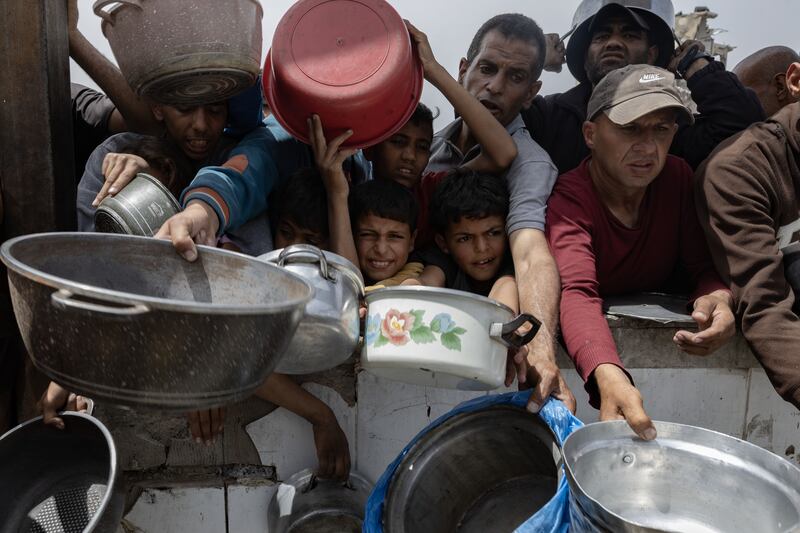 Palestinians jostle for food at a charity kitchen in Jabalia in the Gaza Strip. Photograph: Saher Alghorra/The New York Times
                      