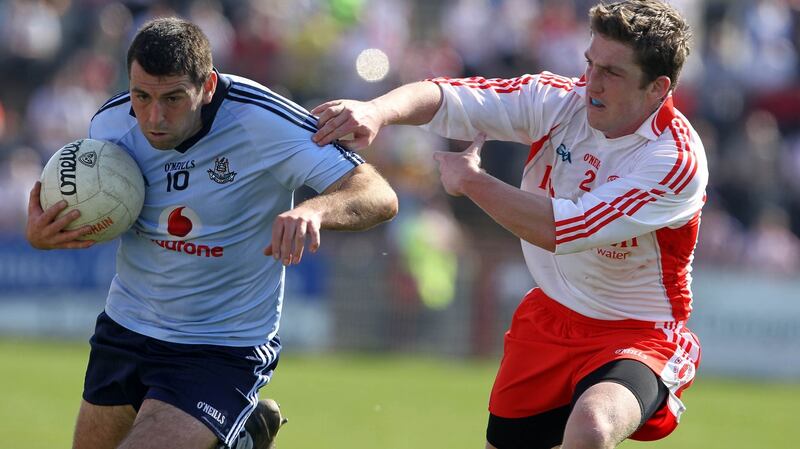David Henry of Dublin is tackled by Dermot Carlin of Tyrone. Photo: Donall Farmer/Inpho