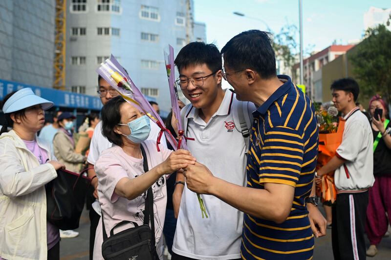 A student celebrates with his relatives as he walks out of a school after finishing his national college entrance examinations, known as the gaokao, in Beijing this week. Photo: Wang Zhao / AFP via Getty Images