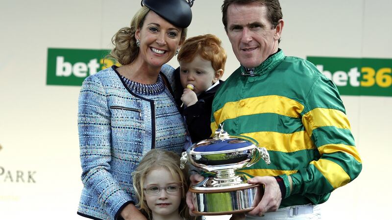 Tony McCoy holds the champion jockey’s trophy beside his  wife Chanelle and children Eve and Archie at Sandown racecourse on April 25, 2015. Photo:  Alan Crowhurst/Getty Images
