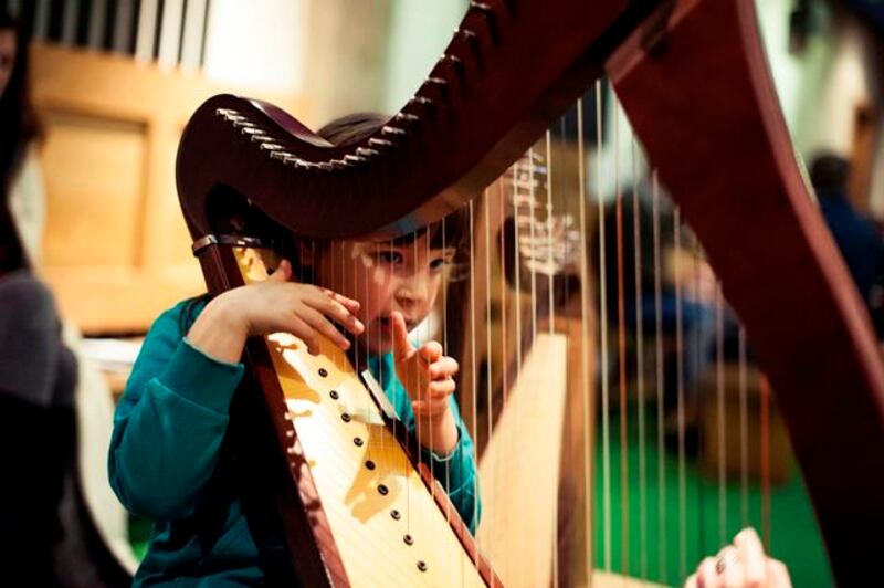 A girl plays harp as part of Tradfest in Dublin