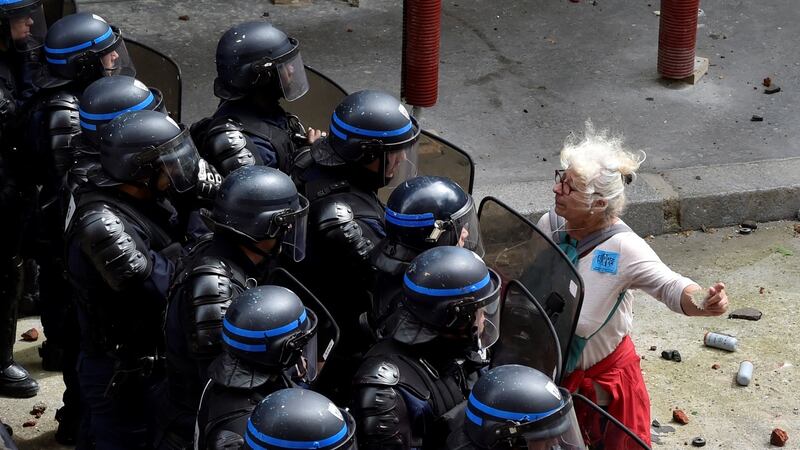 A woman stands in front of police officers as they block access to a street during a protest against proposed labour reforms in Paris in June  2016.  Photograph:  Alain Jocard/AFP/Getty Images