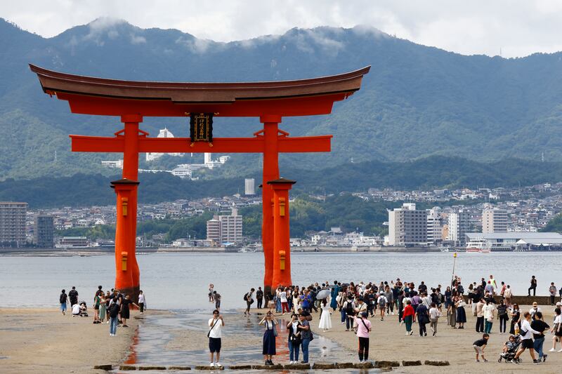 Tourists in front of a giant "torii" gateway at Itsukushima Shrine on Miyajima Island in Hatsukaichi in Hiroshima Prefecture. Photograph: James Matsumoto/SOPA Images/LightRocket via Getty