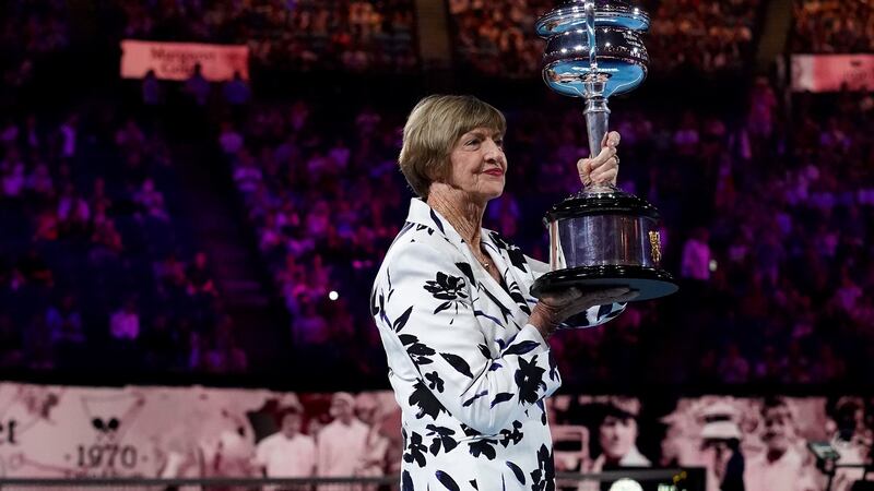 Margaret Court is presented with a replica trophy during a ceremony to mark the 50th anniversary of her Grand Slam win at the Australian Open. Photo: Scott Barbour/EPA