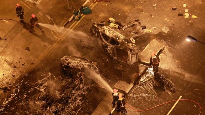 Singapore’s civil defence officers extinguish burning vehicles following a riot in Singapore’s Little India district today. Photograph: Dennis Thong/Lianhe Zaobao/Reuters