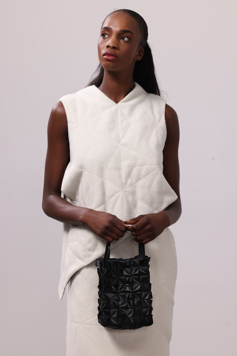 Off-white top and skirt in deadstock wool lined in black with stitch detailing handmade to order. Black squares duchesse satin bag with ribbon embellishment both by Helen Hayes