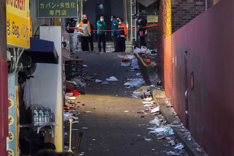 Officials at the alleyway where most of the deaths occurred in the crowd surge. Photograph: Chang W Lee/The New York Times