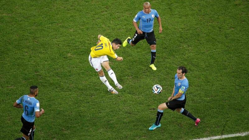 Colombia’s James Rodriguez (10) scores a volley past Uruguay’s Diego Godin (right), Alvaro Pereira (left) and Egidio Arevalo Rios  at the Maracana Stadium in Rio de Janeiro. Photograph: Felipe Dana / Reuters