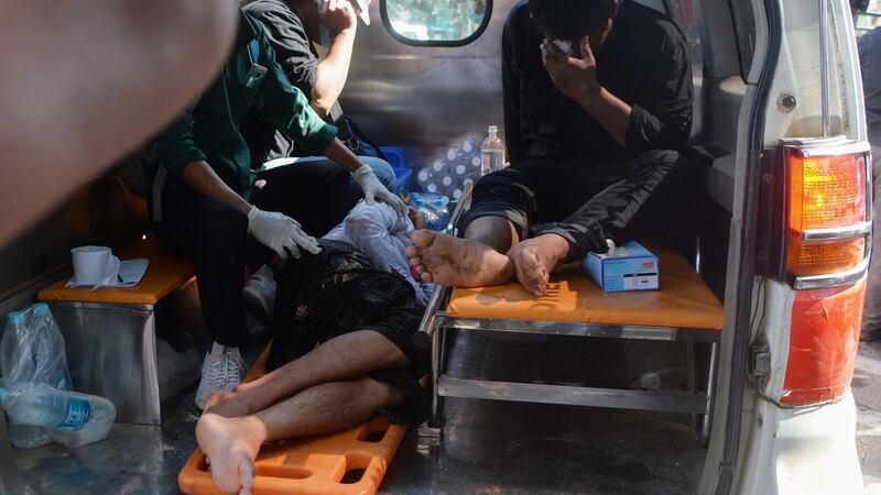 People receive first aid in the back of a vehicle after Myanmar police fired water cannon at protesters during a demonstration  in  Naypyidaw on Tuesday. Photograph: STR/AFP via Getty Images