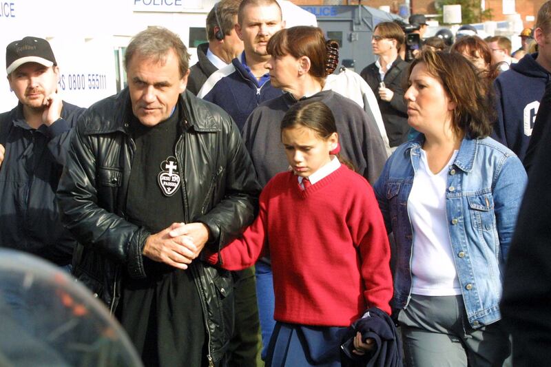 Fr Aidan Troy helps Catholic children being escorted by police to Holy Cross school on the Ardoyne Road, Belfast in September 2001. Photograph: RollingNews.ie