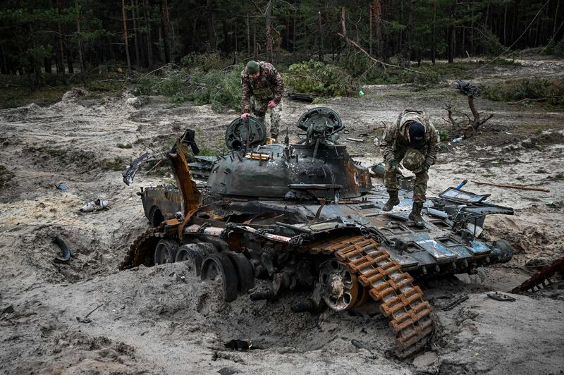 Ukrainian servicemen inspect a destroyed Russian tank near Kivsharivka village in a suburb of Kupiansk, Kharkiv region. Photograph: Sergey Bobok/Getty Images