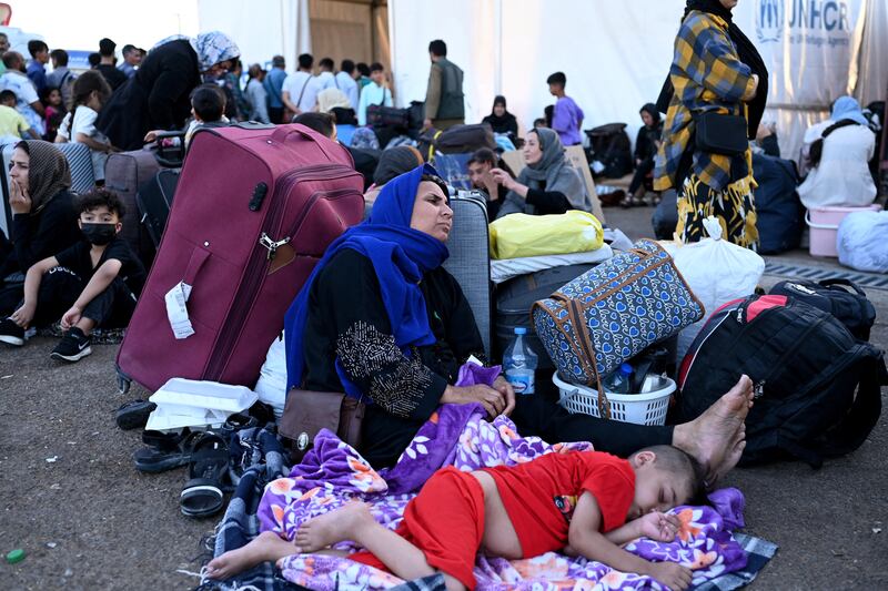 Afghan refugees rest with their belongings after arriving at the zero point of the Islam-Qala border crossing between Afghanistan and Iran in June following their deportation from Iran. Photograph: Wakil Kohsar/AFP via Getty Images 