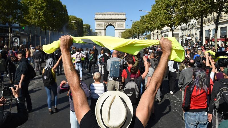 A man holds up a yellow vest in front of the Arc de Triomphe on the Champs Elysees in Paris during an anti-government demonstration on Saturday. Photograph: Lucas Barioulet/AFP/Getty