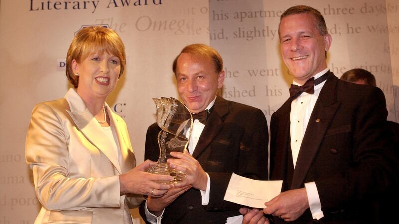 President Mary McAleese presents French author  Michel Houellebecq, winner in 2002, with his award along with Colm Hendrick of  IMPAC. Photograph: Dara MacDonaill
