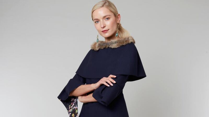 Shelly – two-piece and cape; tailored wool top with Bardot neckline, wide sleeve detail and side frill lined with silk tropical prints and crystal. It can also be made with a tailored mid-calf or full-lenth skirt in a choice of colours.