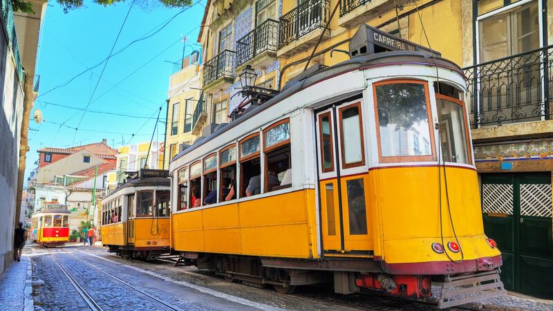 A signature yellow tram moves through Lisbon, Portugal. Photograph: Getty