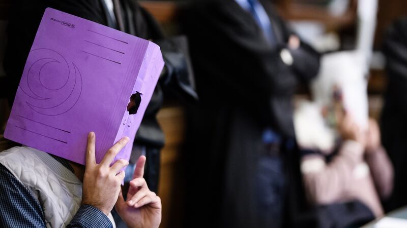 One of the four defendants holds a magazine in front of his face in the courtroom in Berlin on Thursday, at the start of their trial for the theft of a 100kg gold coin froim a museum in 2017. Photograph: Clemens Bilan/EPA