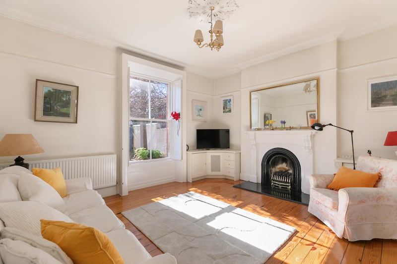 The livingroom has a cast-iron fire surround and timber mantle
