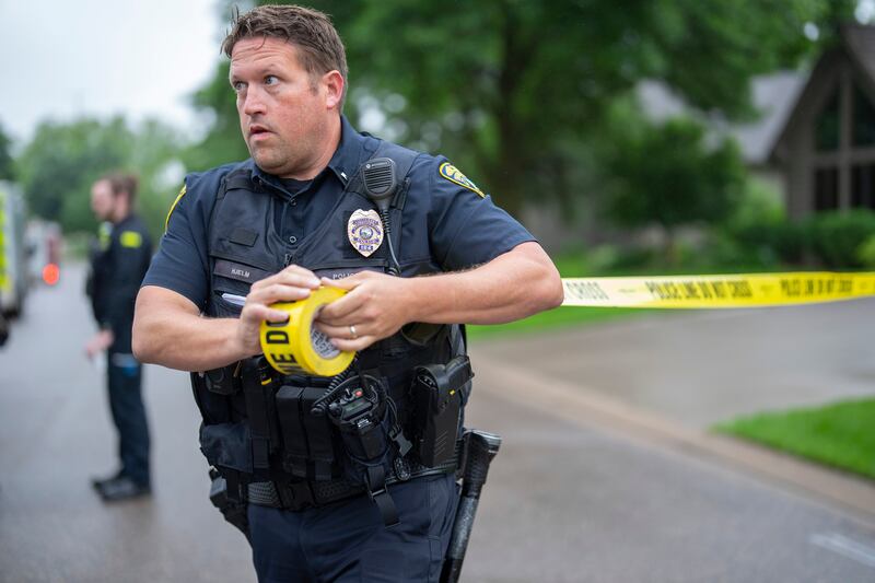 A police officer sets up a perimeter at the crime scene. Photograph: Alex Kormann/ Star Tribune via AP