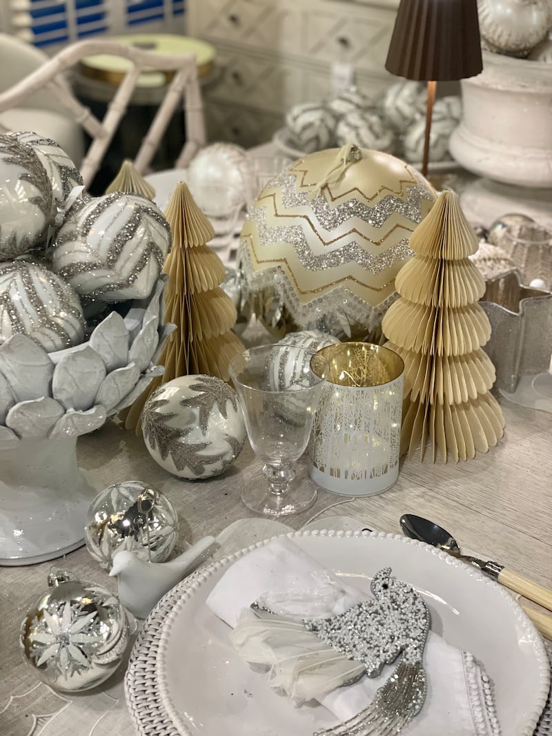 Hedgeroe home: white edge bobble plate (€121 set of four); coated linen table runner (€130); oversized gold and silver art deco bauble (€36); LED white woods tealight €15; silver-gold glitter star candle holder (€13); and paper tree in shell (€28).