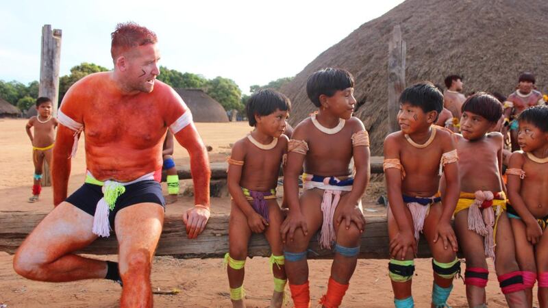 Paddy Collins and children from the Wauja tribe in the documentary series Traveller’s Guide.