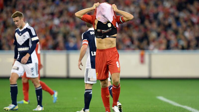 Liverpool captain Steven Gerrard (R) covers his head to show his  StatSports  device after missing a shot on goal against the Melbourne Victory during a football friendly match. Photograph: Mal Fairclough/AFP/Getty Images