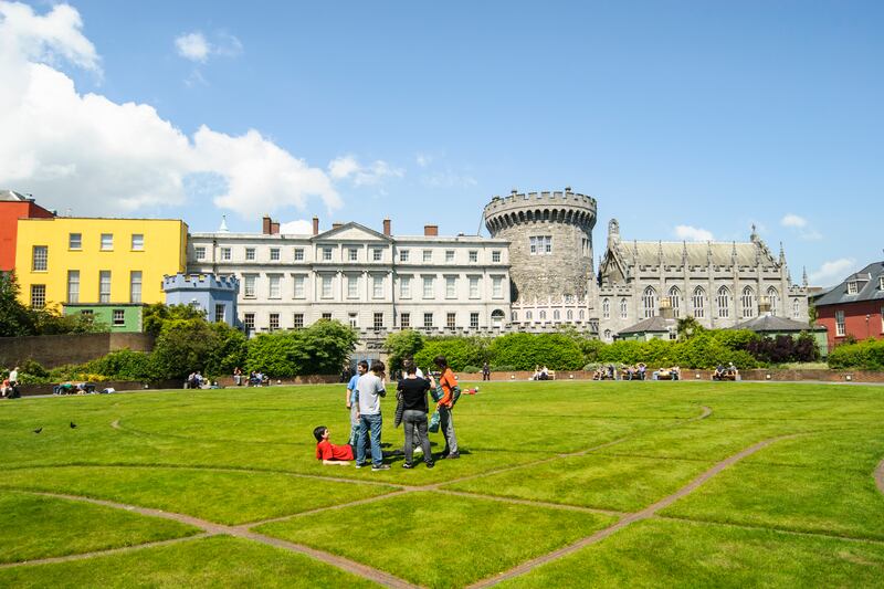 Students in the Dubh Linn gardens at Dublin Castle, a pleasant stop for visitors walking around the capital.