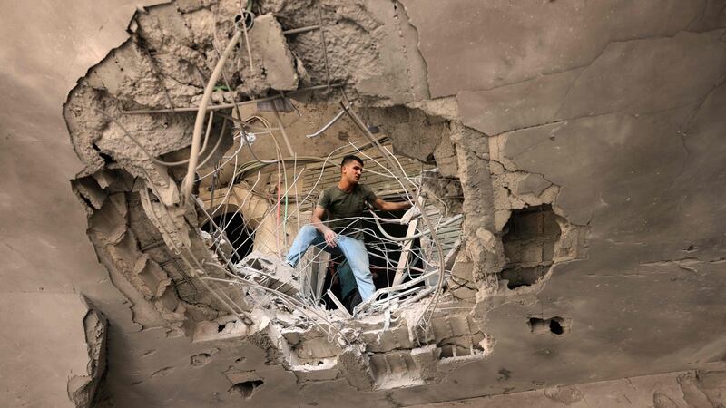 A Palestinian man checks the damage caused  at the Islamic National Bank of the Palestinian Hamas movement in Khan Yunis, in the southern Gaza Strip. Photograph: Said Khatib/AFP via Getty Images