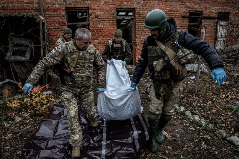 Ukrainian soldiers remove the body of a Russian soldier in the city of Kupiansk-Vuzlovyi near the frontline in Ukraine’s northeastern Kharkiv region on November 1st, 2022. Photograph: Finbarr O'Reilly/The New York Times
