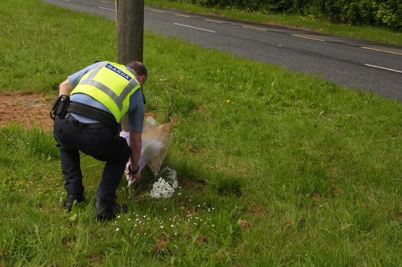 An officer leaves flowers near the scene of where Garda Kevin Flatley died after being hit by a motorcycle as he was recording vehicles' speeds on Sunday afternoon. Photograph: Niall Carson/ PA Wire