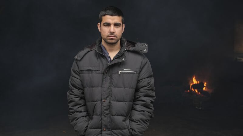 Migrant Jamshid Shadab at the entrance of a derelict customs warehouse in Belgrade, Serbia. Photograph:  Marko Djurica/Reuters
