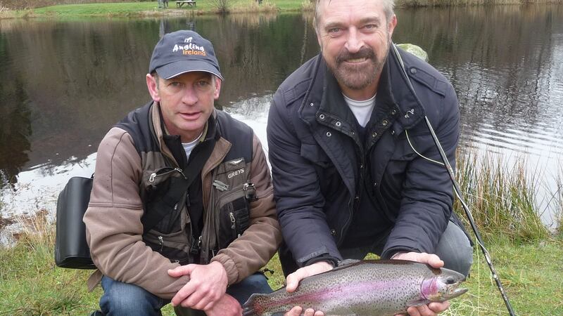 RTE’s Fergal Keane with a 3lb rainbow trout at Annamoe, alongside IFI’s Des Chew