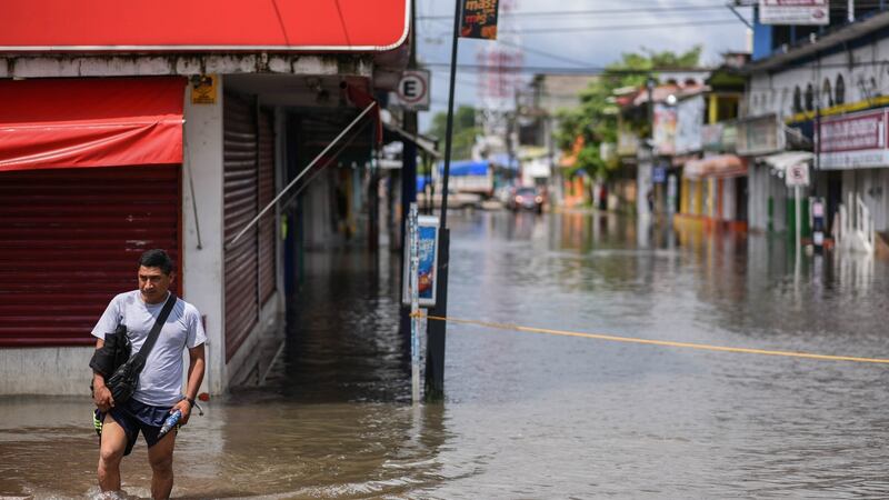 A man crosses a flooded street in the municipality of Minatitlan, south of the state of Veracruz, Mexico. Photograph: Angel Hernandez/EPA
