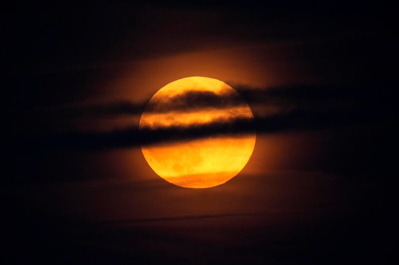 US: Harvest supermoon rises through clouds over the Atlantic Ocean off the coast of Camden, Maine. Photograph: AP