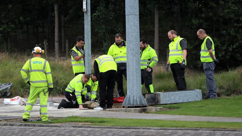 Workers clear debris and reinstall traffic lights at the scene outside T2 at Dublin Airport this morning after an empty  bus rolled down a ramp smashing  traffic lights and signs. Photograph: Collins